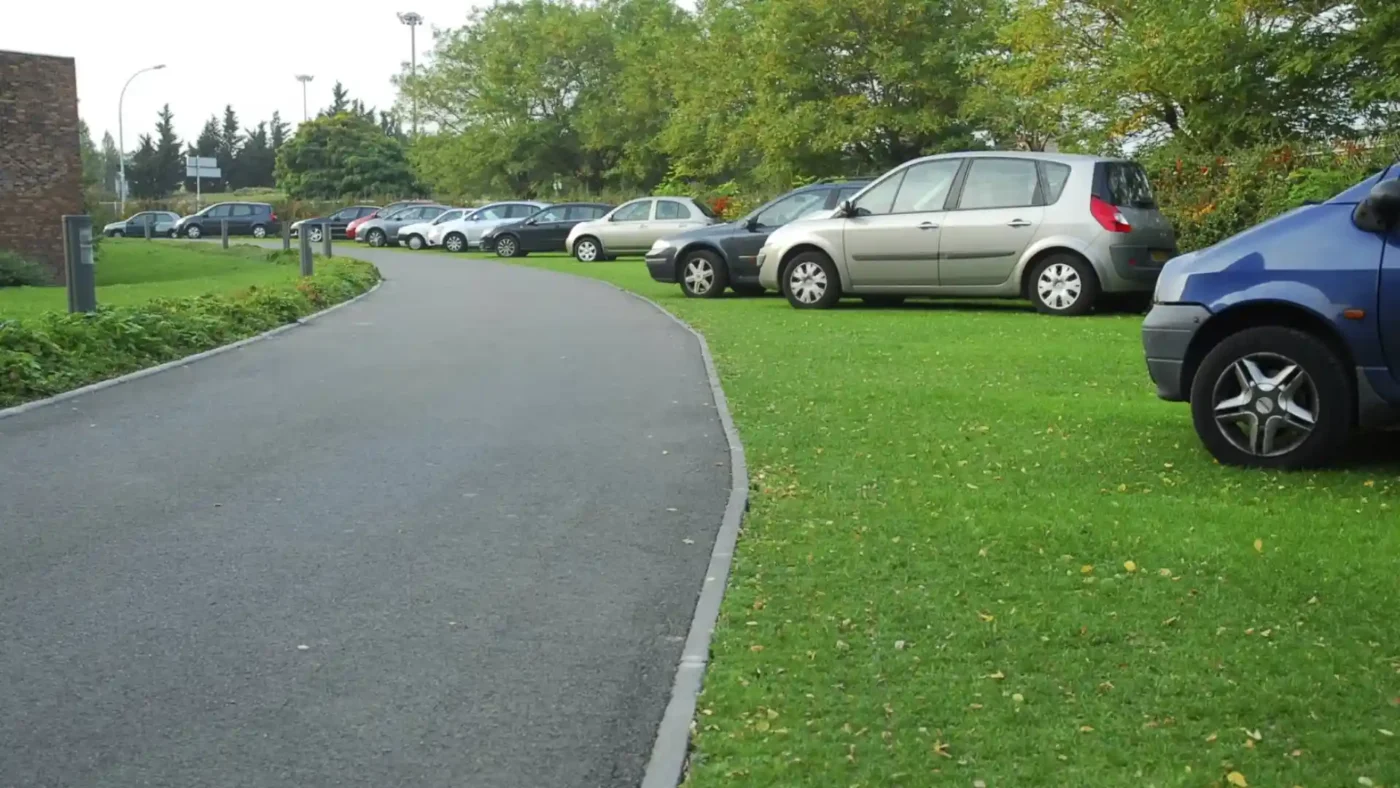 Zatravňovací dlažba ECORASTER – zelené parkovací stání s automobilem
